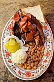 Barbecue-Rippchen, Würstchen mit Baked Beans, Kartoffelbrei, Weißbrot, Zwiebeln und Essiggurken (Texas, USA)