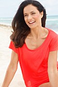 Brünette Frau in rotem T-Shirt am Strand