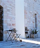 Delicate metal garden furniture against stone walls