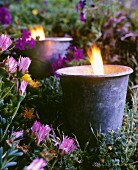 Brennende Gartenkerzen im abendlichen Blumenbeet
