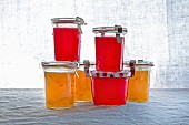 Raspberry jelly and orange marmalade in preserving jars