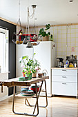 Alte Werkbank mit Pflanzen in der Küche mit Möbelmix