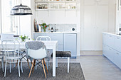 Dining table and various chairs in bright kitchen-dining room