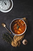 Pork stew with vegetables with napkin on old table