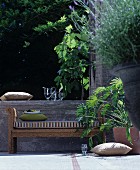 Bank aus Korb auf sommerlicher Terrasse mit Pflanzen