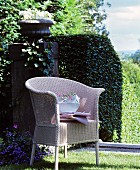 Stacked crockery on wicker chair in classic summer garden