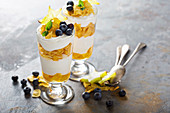 Yogurt cereal parfait with mango and tropical fruits, layered dessert or breakfast