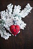 Rotes Herz und verschneite Zweige als Weihnachtsdeko