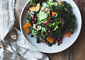 Kale salad with herbs, pomegranate, persimmon