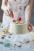 Woman is decorating a chiffon cake on marble table