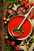 Homemade Tomato soup on wooden table, top view