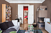 Brown walls and fireplace in living room with view through double doors