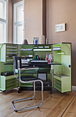 Black cantilever chair in front of office in folding steamer trunk