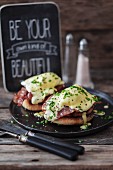 Eggs benedict on a black plate