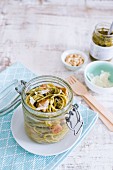 Spaghetti with chicken and pesto in a glass jar