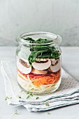 Raw salad in a jar, cabbage, carrots, radish, champignons and spinach, vegan