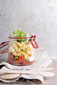 Pasta salad with tomatoes, mozzarella and basil in a glass jar
