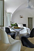Black and white Panton chairs at round table with glass top in period interior