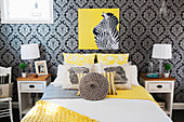 Bedroom with dark patterned wallpaper and yellow accents