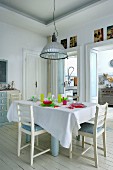 Set table and colourful glass crockery on white wooden floor in dining area