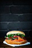 A bagel with smoked salmon, cucumber, tomato and rocket