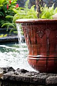 Overflowing ceramic pot in pool