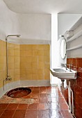 Reclaimed tiled and vertical light shaft in bathroom