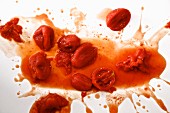 Canned Tomatoes splashed on a white background
