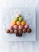 Macaroons and chocolate in shape of tree on plate with sugar