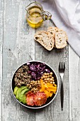A veggie bowl with quinoa, chickpeas, avocado, peppers, red cabbage and blood oranges