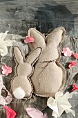 Two fabric rabbits with zig-zag edge and paper flowers