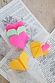 Origami hearts on book pages and transparent tissue paper