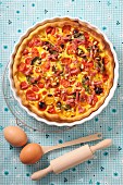 Quiche with cherry tomatoes, spinach, bacon and pine nuts