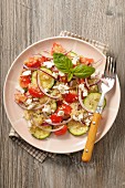 Quinoa salad with courgettes, tomatoes, onions and fresh cheese