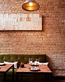 A table set for two in a restaurant with an exposed brick wall
