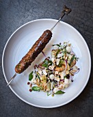 A minced lamb skewer with cauliflower and coconut salad