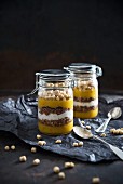 Mango and apple smoothie, chocolate coconut muesli, soy yogurt and oat pops in glass jars