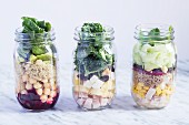 Different layered salads in glass jars