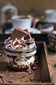 Creamy dessert with mascarpone, hazelnuts and chocolate, topped with chocolate cookies and whipped cream, served with coffee