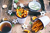 Sweet Potatoes Fries with sae salt flakes and fresh mint leaves; served on a wooden table