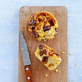 A caramel and peanut cupcake on a chopping board