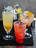 A lemon and orange fizz with cassis, a peach bellini and a shirley temple with strawberries (cocktails)