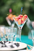 A glass of cherries on a garden table