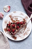 Tiramisu with cherry and chocolate on a white plate
