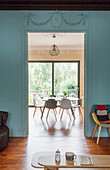 View from living room with dove-grey wall into dining room with table and chairs