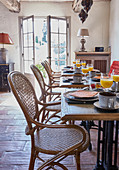 Tables set for breakfast and vintage cane chairs in dining room