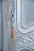 Schlüssel mit Quaste an antiker, kunsthandwerklicher Holztür