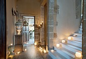 Foot of staircase with many lit candles in historical building