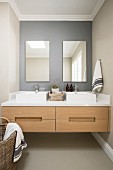 Twin countertop sinks on floating washstand in niche