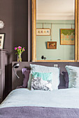 Old cabinet next to bed in two-tone bedroom